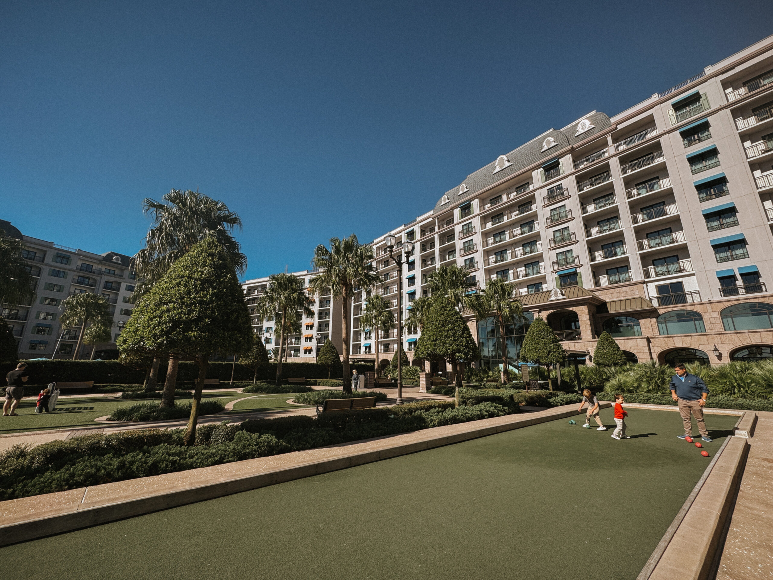 The outdoor area of Disney'w Riviera Resort with clear blue sky and greenery.